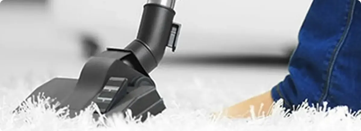 Close-up of a professional vacuuming a white carpet in Kaneohe.